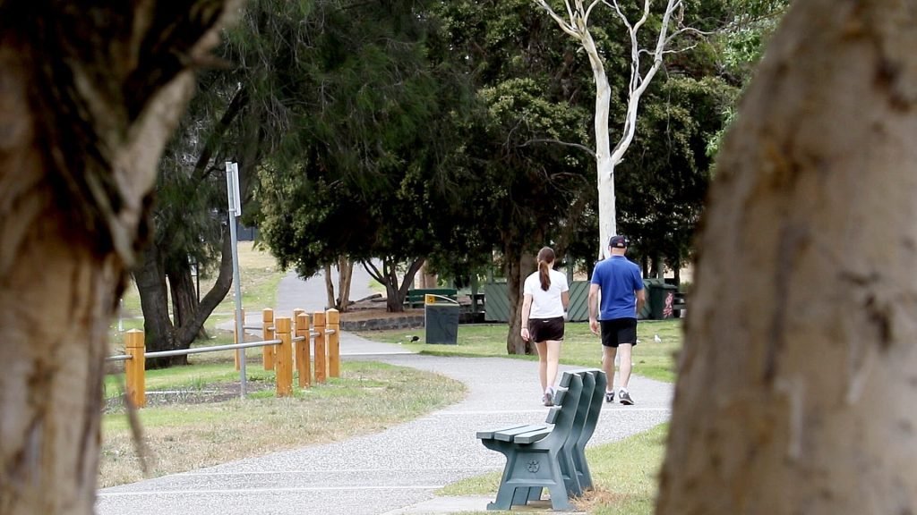 Walking path beside Edwardes Lake in Reservoir, with people enjoying the park