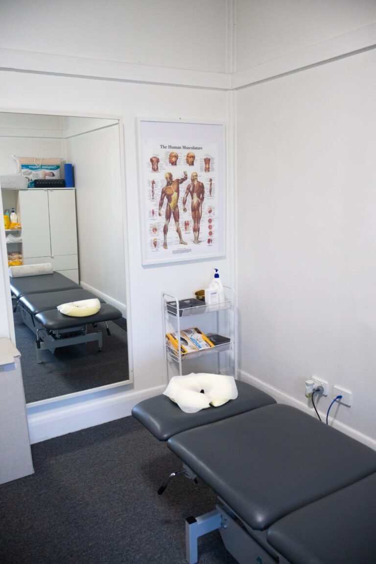Mernda clinic treatment room with massage table, mirror and human musculature chart