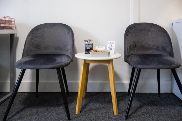 Comfortable grey velvet chairs and side table in the waiting area at our Mernda clinic